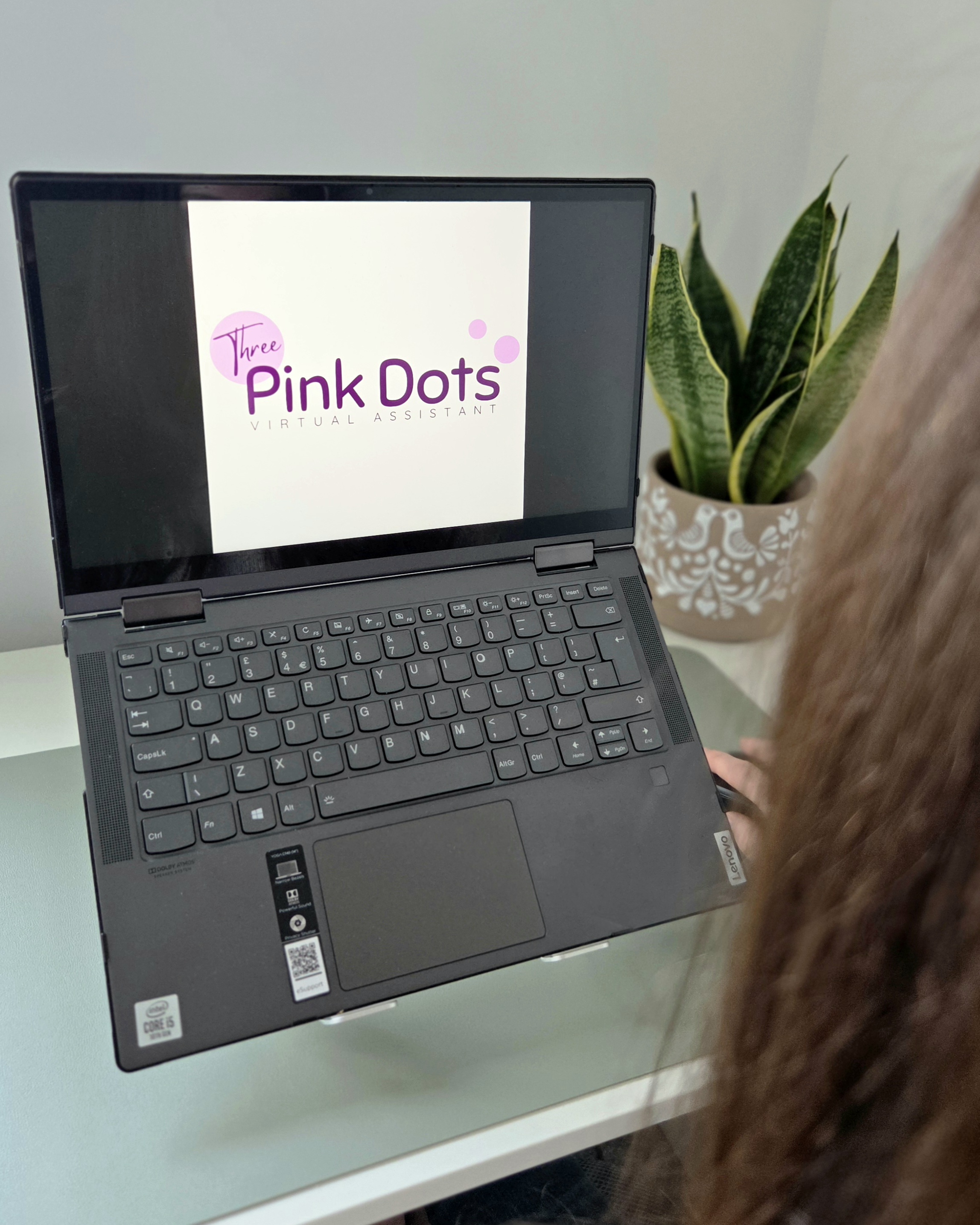 image of laptop on a desk with the three pink dots logo on the screen